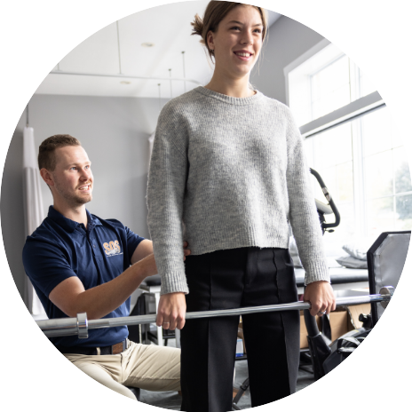 An SOS physiotherapist helping a patient with their posture while performing an exercise
