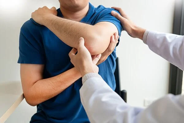 Physiotherapist assessing shoulder and neck of patient
