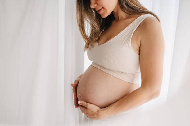 pregnant woman cradles baby bump