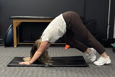 Downward Dog with Calf Extensions Stretch demonstrated by physiotherapist Anna Pelczar